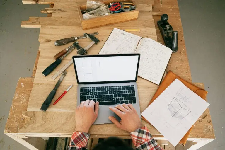Laptop on a table with tools and construction plans
