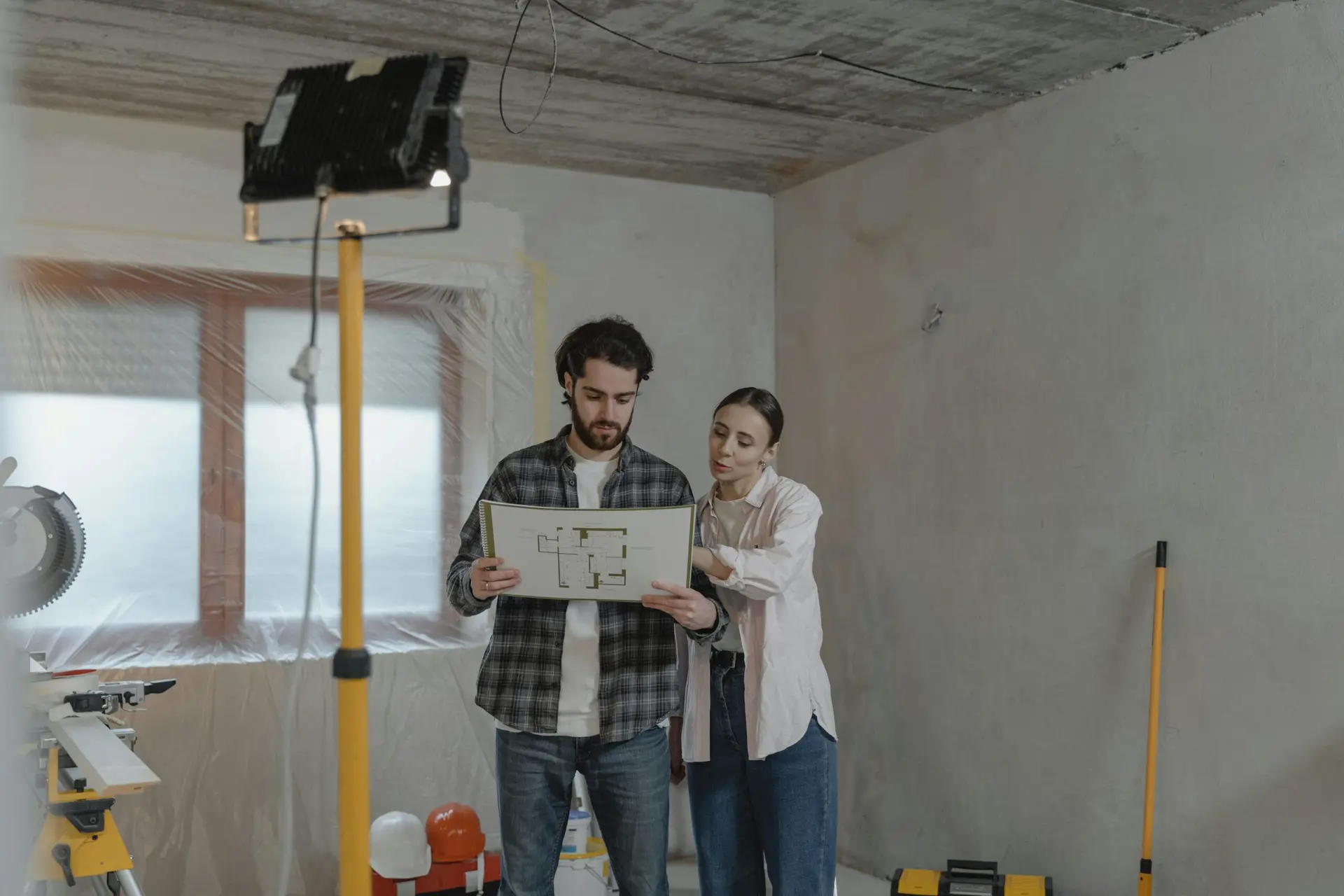 Couple looking at house plans during construction